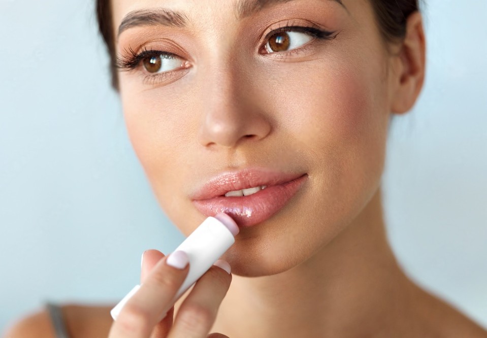 Beautiful Woman With Beauty Face Applies Balm On Soft Lips. Skin Care